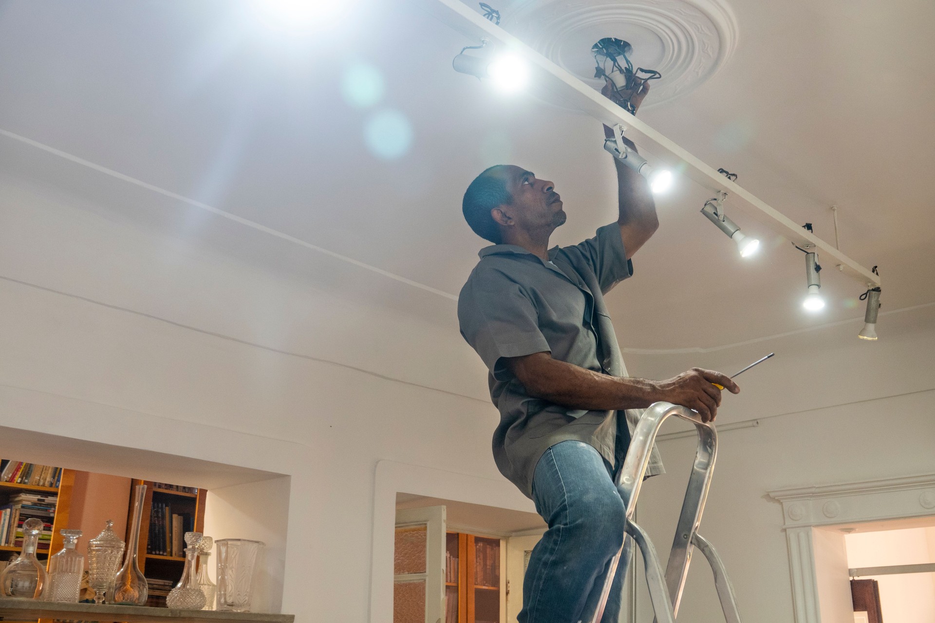 Electricista repara el cableado de bombillas en una habitación de la casa